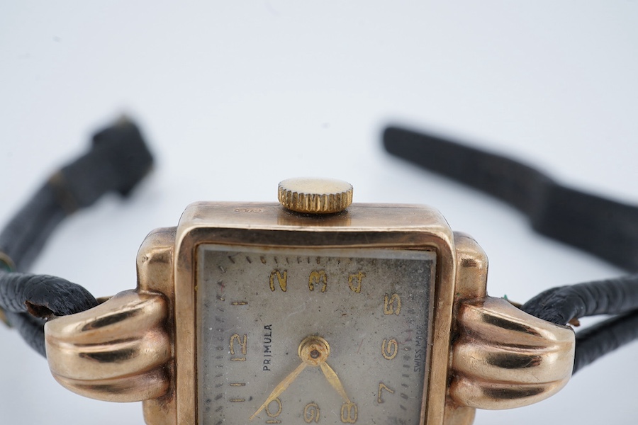 A lady's 9ct gold Primula manual wind wrist watch, with fluted lugs, on a leather strap. Condition - fair